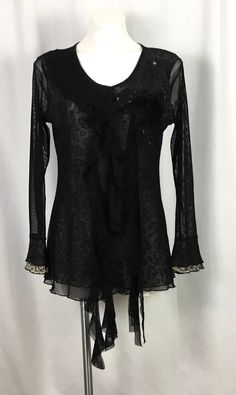 Pretty Angel -black blouse-semi Sheer-very fine soft netting over a sparkle animal print very fine net lining SIZE-L Scoop neckline-one side having a ruffle cascading down the front -the other side a flower appliqué -surrounded by black net and bugle beads-with four strands of fabric flowing from the flower down the front Ruffled sleeves 55% silk-35% rayon-10% spandex-good 4 way stretch Dry clean only  Like new condition Black Lace Tops With Ruffles, Long Sleeve Blouse With Lace Trim For Party, Party Blouse With Lace Trim And Long Sleeves, Party Mesh Top With Lace Trim And Stretch, Elegant Stretch Lace Patchwork Blouse, Fitted Lace Tops With Ruffles, Elegant Stretch Lace Mesh Top, Elegant Fitted Mesh Top With Lace Detail, Elegant Fitted Lace Mesh Top