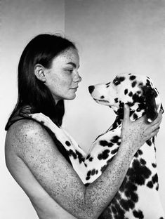 a woman holding a dalmatian dog in her arms