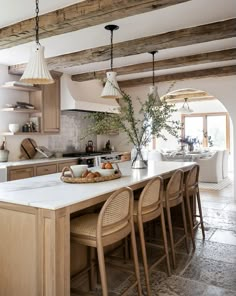 a large kitchen with wooden cabinets and white counter tops, along with bar stools