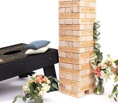 a stack of wooden blocks sitting next to vases filled with flowers