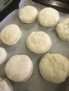 eight uncooked doughnuts sitting on top of a baking sheet