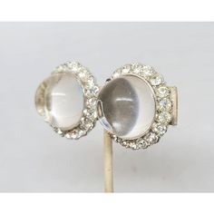 1960s round rhodium plated large unfoiled open backed clear rhinestone cabochon with round clear rhinestone accent surround clip earrings. Marked "Castlecliff" on the clips. Measure: 1 1/4 inches across. Excellent condition. Silver Crystal Clip-on Earrings For Formal Events, Silver Round Clip-on Earrings For Evening, Silver Round Clip-on Earrings With Sparkling Stones, Silver Jeweled Crystal Clip-on Earrings, Formal Clip-on Round Crystal Earrings, Vintage Silver Clip-on Earrings With Rhinestones, Silver Round Clip-on Crystal Earrings, Vintage Silver Jeweled Clip-on Earrings, Vintage Silver Round Crystal Earrings