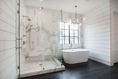 a bathroom with white walls and black flooring is featured in the article 8 porcelain slab showers