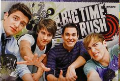 four young men posing in front of a graffiti wall with the words big time rush written on it