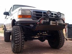 the front end of a pickup truck with four lights on it's bumpers