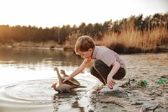 a young boy playing in the water with an elephant