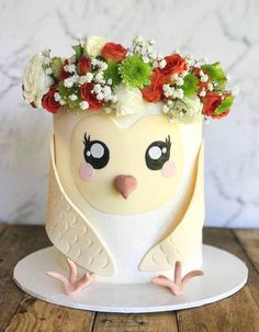 a cake decorated with flowers and an owl face