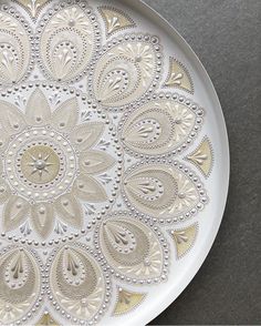 a white and gold plate sitting on top of a table next to a black counter