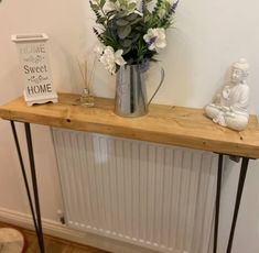 a vase with flowers sitting on top of a wooden table next to a radiator