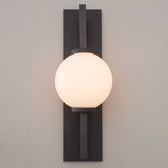 a light that is on the wall next to a white wall mounted object with a black frame