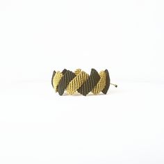 This black and gold zig zag macrame cuff bracelet is handwoven with a special macrame technic that brings thousands of knots together to create a unique, luxurious and elegant design. It's made of waterproof and long lasting waxed cord so that you can enjoy this timeless design for years. With its adjustable closure, it is suitable for all wrist sizes. Black Braided Bracelets As Gift, Black Woven Braided Bracelets As Gift, Black Woven Braided Bracelets For Gift, Adjustable Gold Handwoven Friendship Bracelets, Black Woven Braided Bracelet For Gifts, Adjustable Woven Gold Friendship Bracelets, Adjustable Black Woven Friendship Bracelets, Black Macrame Braided Bracelet For Gift, Adjustable Black Handwoven Jewelry