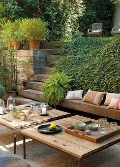 an outdoor living area with couches, tables and plants