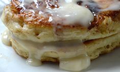 a stack of pancakes covered in icing on top of a white plate