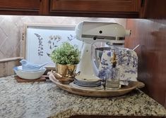 a kitchen counter top with a mixer on it and some dishes in front of it