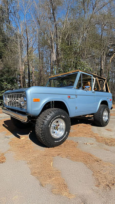 Vintage light blue Ford Bronco with removable top and large off-road tires, parked in a wooded area with bare trees in the background. Baby Blue Ford Bronco, Baby Blue Bronco, Blue Ford Bronco, Blue Bronco, Old Bronco, Fall Sunset, Classic Bronco, Early Bronco, Simpler Times