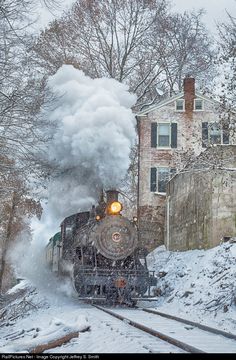 an old steam engine train traveling through the snow