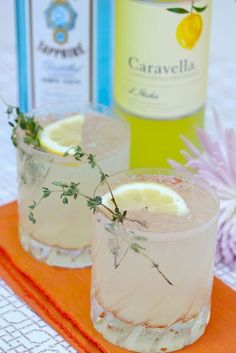 two glasses filled with lemonade and garnish on top of an orange napkin