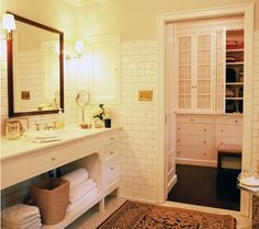 a bathroom with a sink, mirror and towels on the counter in front of it