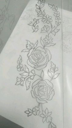 a piece of paper that has some flowers drawn on it and is laying next to another piece of paper