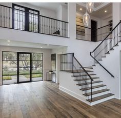 a large open floor plan with stairs and glass doors