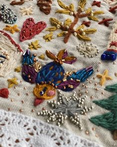 an embroidered table cloth with christmas decorations on it