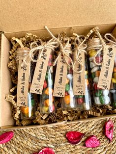 a box filled with lots of different types of candies in glass bottles next to straw baskets