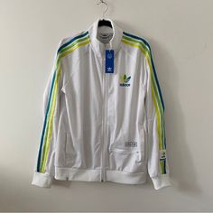 Condition: New With Tag Size: Medium Color: White Material: 100% Recycled Polyester Adidas White Athleisure Track Jacket, Adidas White Winter Track Jacket, White Adidas Windbreaker For Spring, Adidas Urban Spring Track Jacket, Adidas White Track Jacket For Winter, White Adidas Track Jacket For Winter, White Sports Outerwear With Three Stripes Branding, Retro White Cotton Outerwear, White Retro Cotton Outerwear