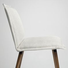 a white upholstered chair with wooden legs