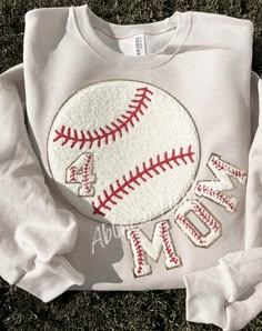 a white shirt with a baseball on it and the words mom spelled out in red