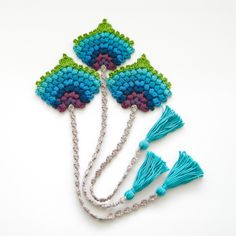 four pieces of beaded jewelry with tassels