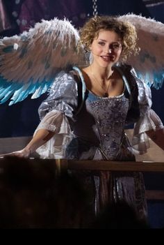 a woman dressed as an angel with blue wings