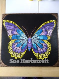 a colorful butterfly with the words sue hebstret on it