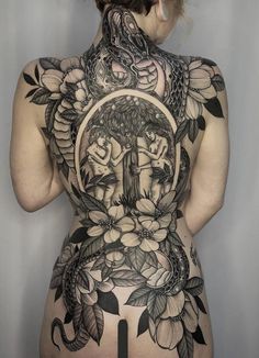 the back of a woman's body with tattoos on it