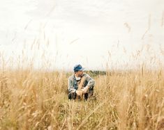 a man sitting in the middle of tall grass