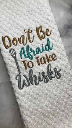 a white towel with the words don't be afraid to take whisks on it