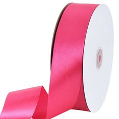 a roll of pink satin ribbon on a white background