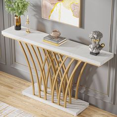 a white marble console table with gold accents in a grey living room, next to a painting on the wall