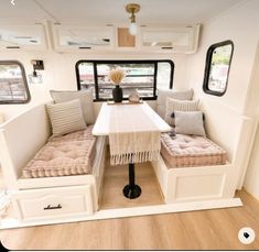 the inside of a recreational vehicle with two couches and a dining table in it