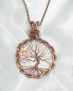 This copper, wire wrapped tree of life pendant features a shimmering slice of crescent moon peaking through the branches. The circular frame was created from repurposed 12 gauge copper wire, then twisted, shaped and hammered flat. A finer gauge copper wire was used for the tree and its branches, with the roots of the tree anchored to the frame. Cut from sheet metal, the crescent moon sits on one side of the tree. This larger size tree of life measures 1 7/8" around and is 2 5/8 inches tall including the bale. It is suspended from a 28" copper chain with a custom made S-clasp closure.  This one-of-a-kind pendant necklace arrives in a beautiful gift box ready for gifting yourself or your someone special! Moon Tree Of Life, Wire Wrapped Tree Of Life, Wire Wrapped Tree, Copper Tree, Moon Tree, Circular Frame, Autumn Tree, 12 Gauge, Tree Of Life Pendant