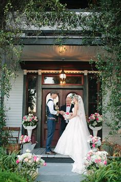 a bride and groom are standing in front of the door to their wedding ceremony venue