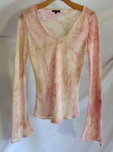 Sheer tie dye top for vintage women A.K.A. Made in the 1990s. Size Medium. Made of slightly transparent pink and yellow polyester; Slightly fitted, the bottom is rounded; Long flared sleeves; Slips on from the top; V-neck opening; Two leather cords to tie; 70s hippie style; Very pretty and light, it will go perfectly with a bodysuit, a camisole or over a swimsuit! Washable and quick-drying fabric. Measures: Tag: As Known As, M/M Length: Shoulder to shoulder: Sleeves: Bust: Size: In very good con Summer Tie-dye Long Sleeve Blouse, Summer Tie Dye Long Sleeve Blouse, Summer Long Sleeve Tie Dye Blouse, Long Sleeve Tie-dye Blouse For Summer, Long Sleeve Tie Dye Blouse For Summer, Spring Tie Dye Tops, Spring Tie Dye Stretch Top, Spring Tie-dye Fitted Tops, Spring Tie Dye Fitted Tops