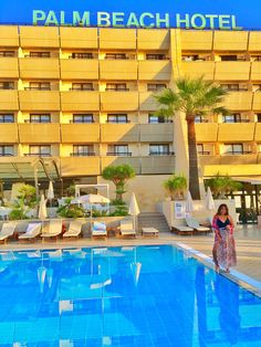 a woman standing in front of a hotel swimming pool