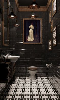 a bathroom with black and white tile flooring and pictures on the wall above the toilet