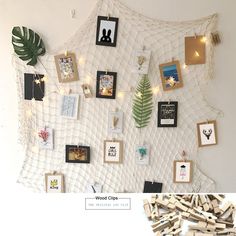 there are many pictures on the wall with clothes pins attached to it and string lights strung around them