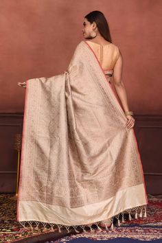 Radiate elegance on festive occasions in this cream golden zari Katan silk Banarasi saree with red edging. It comes with a red blouse piece. Disclaimer: The shown stitched blouse on the model is for display purpose only. The saree comes with a matching blouse piece and finished with fall and piko. Disclaimer: The actual product may vary slightly from the image. These are custom orders, hence expect slight variation in color, placement of the motif or buta. ESTIMATED DELIVERYBecause this is a cus Festive Beige Raw Silk Traditional Wear, Beige Raw Silk Traditional Wear For Ceremonies, Beige Anarkali With Pallu, Beige Anarkali Traditional Wear With Pallu, Cream Raw Silk Traditional Wear With Pallu, Cream Anarkali Art Silk Saree, Anarkali Cream Art Silk Saree, Festive Beige Saree With Traditional Drape, Anarkali Style Cream Art Silk Saree