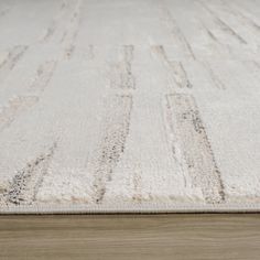 a white rug on top of a wooden floor