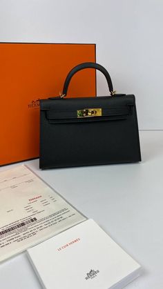 A sophisticated black Epsom leather Hermes Kelly bag with coveted gold hardware.Comes with Hermes signature orange box, shoulder strap and sleeper.d Hermes Kelly 20 Mini bag in classic black.NEW or NOT WEARABLEThe price of the Hermes Kelly 20cm retains its value due to the high demand for this limited style.Last Sale BAG MEASURES:LENGTH 20cm / 8 7/8"TALL 12cm / 4 3/4"DEEP 6cm / 2 3/8" Small Hermes Bag, Black Kelly Bag, Kelly 20 Hermes, Black Mini Kelly, Hermes Mini Bag, Mini Kelly Hermes, Hermes Bags Kelly, Hermes Kelly Black, Kelly Hermes Bag