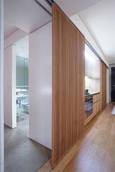 an empty kitchen and living room with wood paneling