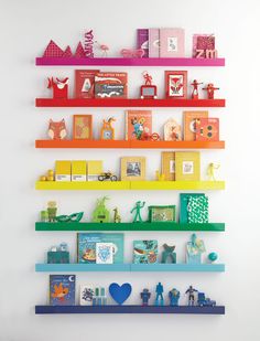 colorful shelves with books and toys on them against a white wall in a children's room