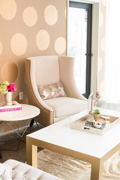 a living room with polka dot wallpaper and two chairs in front of a coffee table